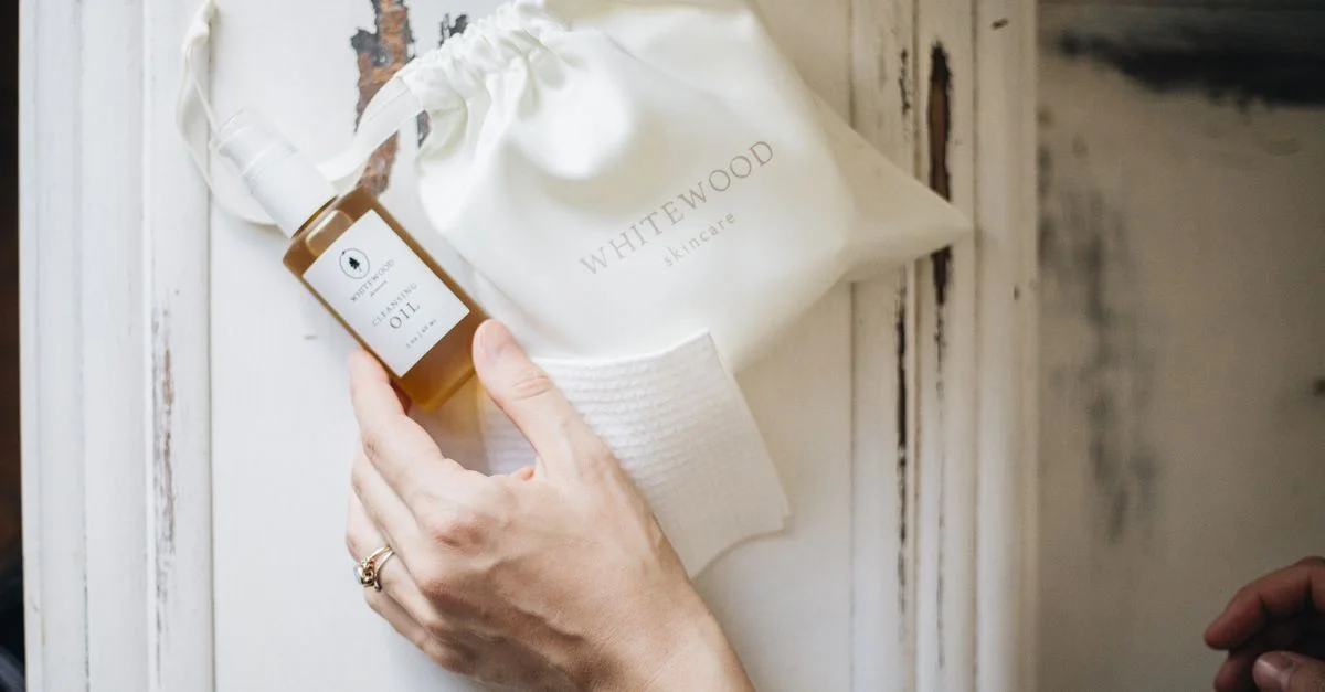 Mise en scène minimaliste d'une routine de soin du visage comprenant une huile visage naturelle et un sac en bois blanc.